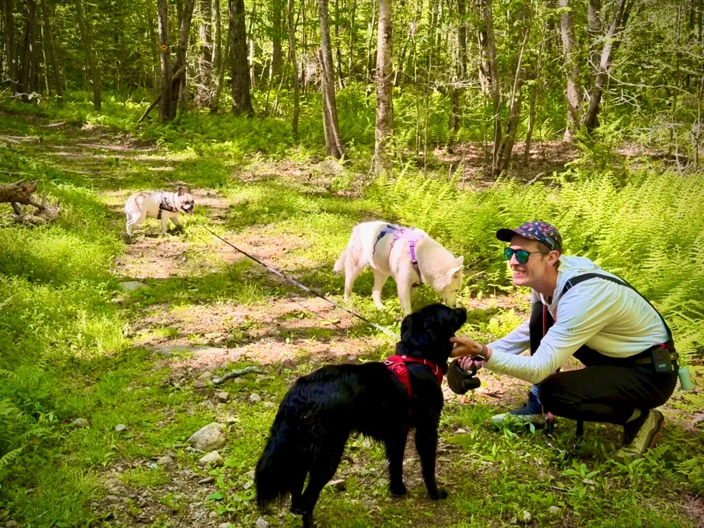 Tom greeting a dog while a small trail group explores nearby